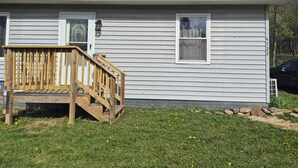 A single-story house with a front porch, a small window, and a door. - Cozy 2-bedroom bungalow in gorgeous Mount Storm with AC (Mount Storm)