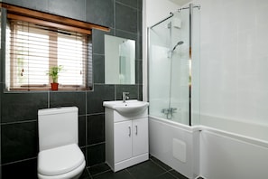 Ein Badezimmer mit Toilette, Waschbecken und einer Duschkabine.
