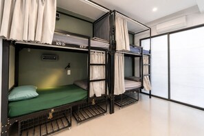 A bunk bed room with a window, a wall socket, and an air conditioning unit. - Two Horses Hostel (Hoi An)