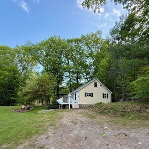 Ein Haus mit Veranda, einer Terrasse und einer Auffahrt mit Kies.