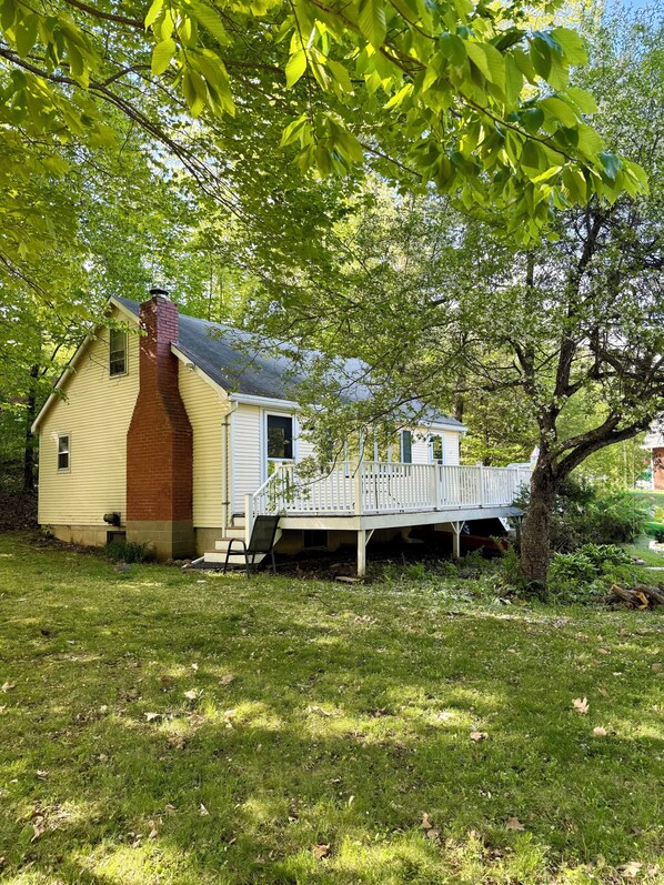 Ein Haus mit Backsteinofen, einer Veranda und einer kleinen Terrasse.