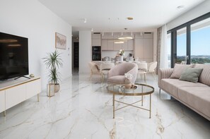 Ein modernes Wohnzimmer mit Fernseher, Sofa und Couchtisch.