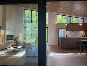 Ein modernes Interieur mit großen Fenstern, einer Küchenzeile und einer Sitzecke.