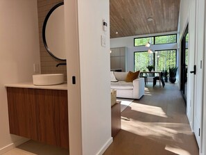 Ein modernes Interieur mit Kücheninsel, Essbereich mit Tisch und Stühlen sowie Wohnbereich mit Sofa.