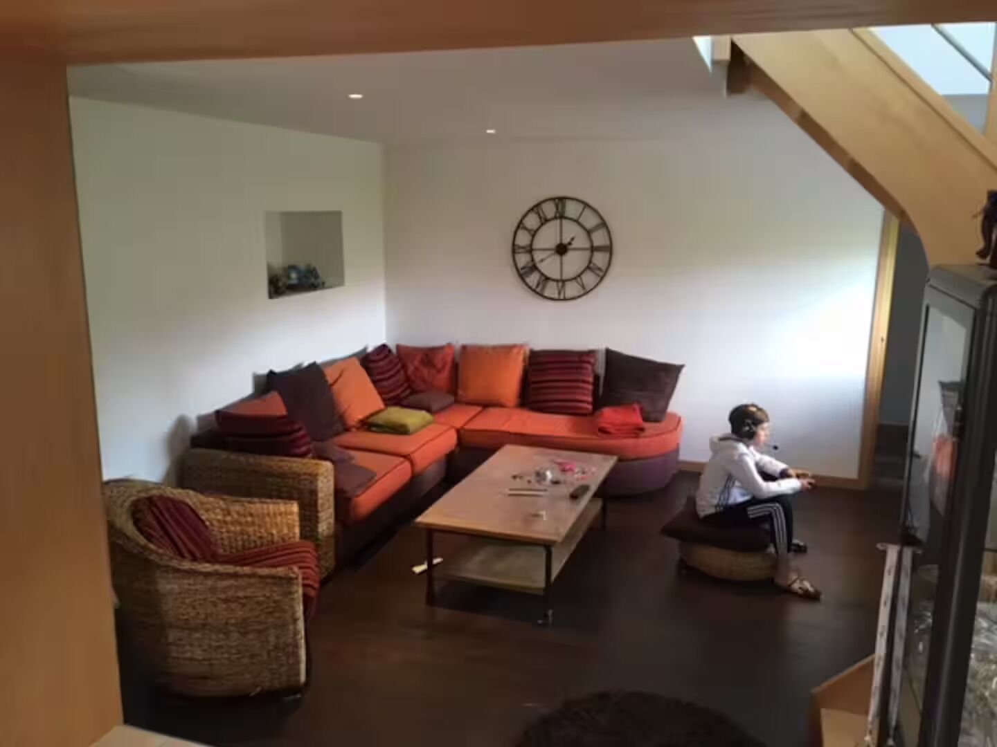 A living room with a sectional sofa, a coffee table, and a child playing.