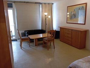 A room with a wooden table, two chairs, a bench, a cabinet, and a painting on the wall.