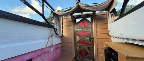A compact cabin with a glass door, a small wooden table, and a bench.