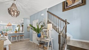 Ein modernes Interieur mit Treppe, Essbereich und Küche.