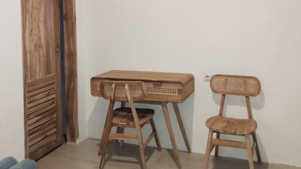 A room with a wooden wardrobe, a desk with a chair, and a bed. - HomeBase Areguling (Kuta)