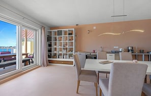 Eine moderne Küche mit Essbereich, großen Fenstern und Meerblick.