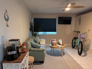 Ein Wohnzimmer mit einer Couch, einem Couchtisch und einem Fahrrad.