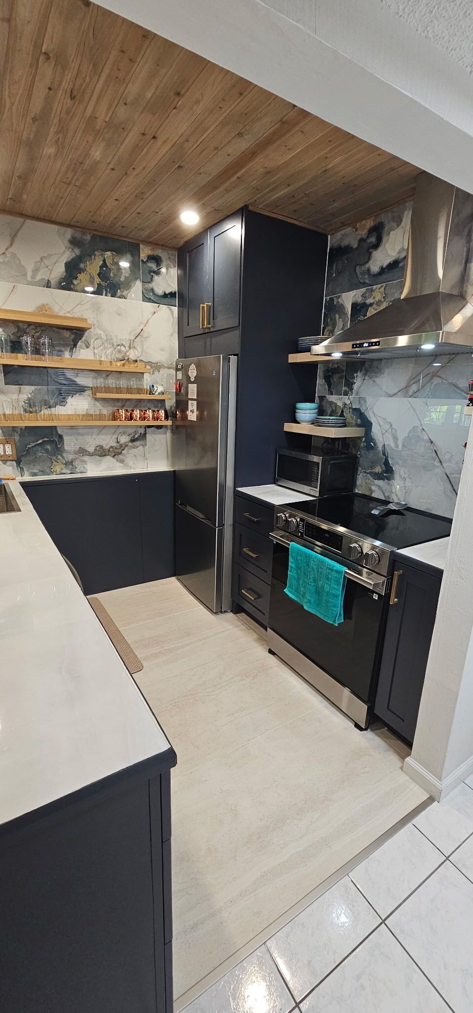 A modern kitchen with a built-in oven, microwave, and stainless steel appliances.