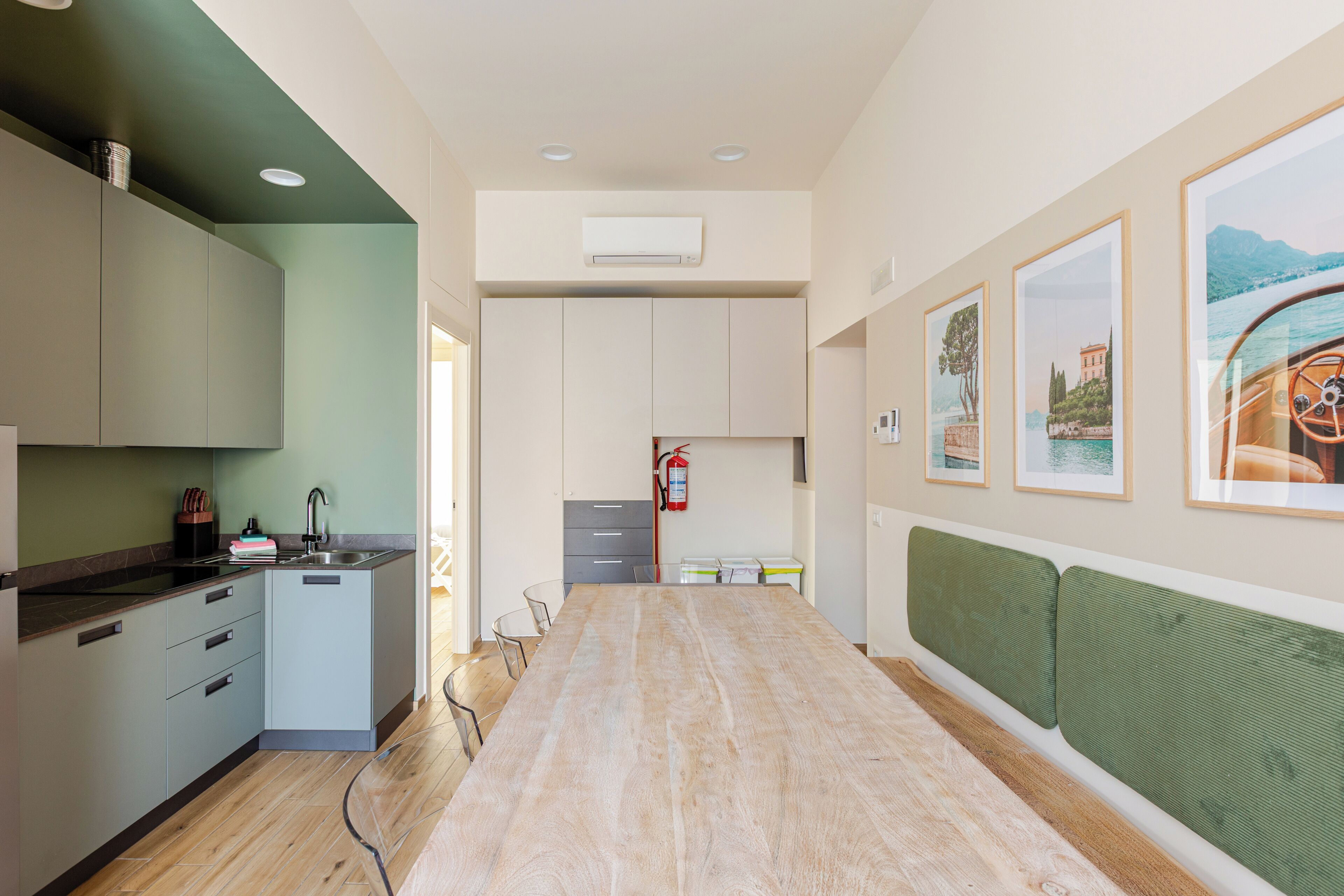 Una cocina moderna con comedor, extintor de incendios y cuadros en la pared.