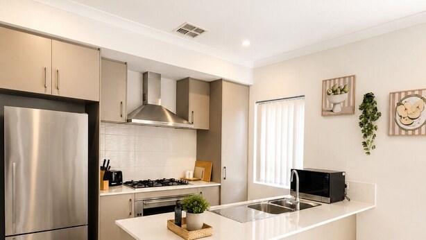 A modern kitchen with a central island, stainless steel appliances, and a clean, minimalist design. - Modern Oasis | 3BR Home (Bassendean)