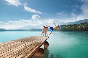 A wooden dock extending into a calm lake with mountains in the background. - Luxury Apartment in Villach (75 m²) (Villach)