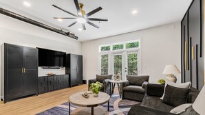 A modern living room with a sofa, coffee table, and a TV. - Luxury 1BR Loft in Atlanta’s Vibrant Heart. (Atlanta)