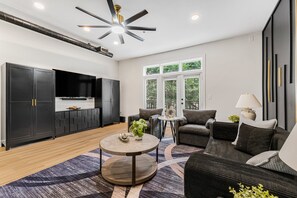 Ein modernes Wohnzimmer mit einer Couch, einem Couchtisch und einem Fernseher.