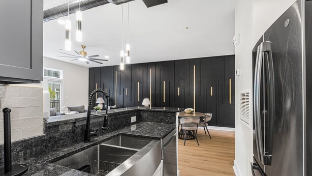 A modern kitchen with granite countertops, stainless steel appliances, and a dining area with a table and chairs. - Luxury 1BR Loft in Atlanta’s Vibrant Heart. (Atlanta)