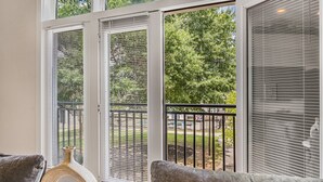 A room with a large sliding glass door leading to a balcony with a metal railing. - Luxury 1BR Loft in Atlanta’s Vibrant Heart. (Atlanta)