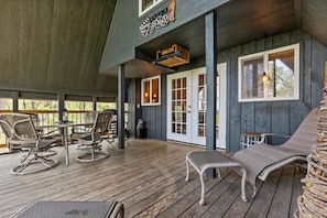 A covered outdoor area with wooden flooring, seating arrangements, and a sign indicating a cinema.