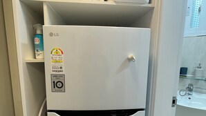 Ein weißer Kühlschrank mit oberplatziertem Mikrowellenherd und Wasserspender, versehen mit einem Energielabel.