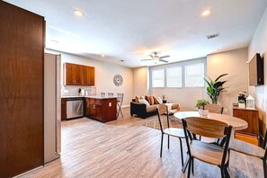 A spacious living area with a dining table, a sofa, and a kitchen in the background. - Modern Cozy 2BR Near Downtown Houston + Parking (Houston)