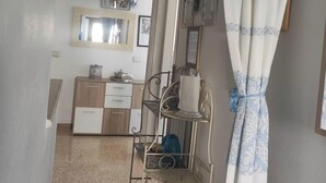 A hallway with a mirror, a shelf with items, and a patterned curtain. - Dalhia's House: stunning gulf and mountain views, Wi-Fi, A/C Free parking (Cala Gonone)