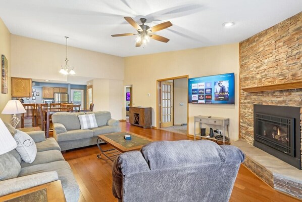 Una sala de estar con chimenea, televisión y comedor.
