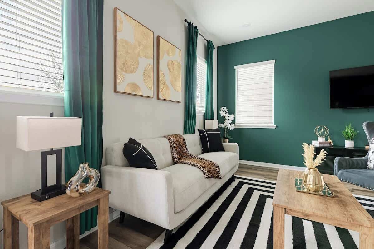 Ein Wohnzimmer mit Sofa, Couchtisch und einem an der Wand befestigten Fernseher.