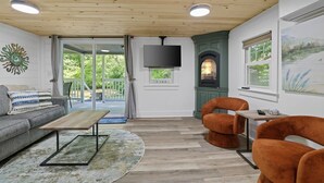Ein Wohnzimmer mit Sofa, Couchtisch, Kamin und Fernseher.