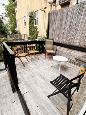 A wooden deck with outdoor furniture, including chairs and a table. - 5BR Jersey City Home – Perfect for World Cup Groups! 
Walk to the PATH train. (Jersey City)