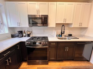 A modern kitchen with white cabinets, a stainless steel range, a microwave, and a dishwasher. - 5BR Jersey City Home – Perfect for World Cup Groups! 
Walk to the PATH train. (Jersey City)