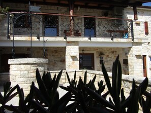 Ein Gebäude aus Stein mit Balkon, Tür und Fenster.