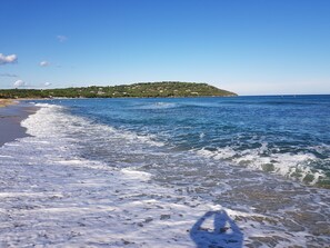 A beach with waves, a clear sky, and a distant hill. - Mobile home for rent at the Plage de Pampelonne St. Tropez-Ramatuelle (Saint-Tropez)