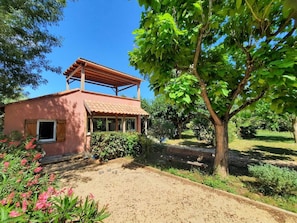 A rustic house with a tiled roof, a covered porch, and a garden with various plants and a tree. - A quiet home in a little slice of paradise - Pétanque court (Roquebrune-sur-Argens)