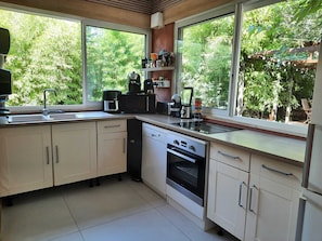 A modern kitchen with a dishwasher, oven, and coffee maker. - A quiet home in a little slice of paradise - Pétanque court (Roquebrune-sur-Argens)