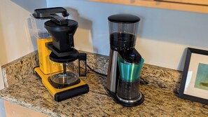 Eine Kaffeemaschine und ein Wasserspender auf einer Granit-Arbeitsplatte.
