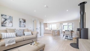 A modern living room with a sofa, coffee table, and artwork. - Luxury House in Templepatrick I Big Garden I Near Airport & Belfast (Templepatrick)