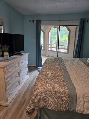 A bedroom with a bed, a dresser, a television, and a window with curtains. - Ocean Ahh, a beautiful 2 BR/2 BA condo less than .4 miles to the beach (Myrtle Beach)