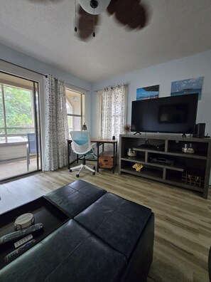A living room with a sofa, a TV, a desk, and a chair. - Ocean Ahh, a beautiful 2 BR/2 BA condo less than .4 miles to the beach (Myrtle Beach)