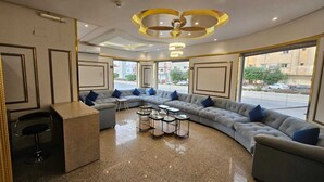 A modern lounge area with a curved sofa, small tables, and a bar counter.