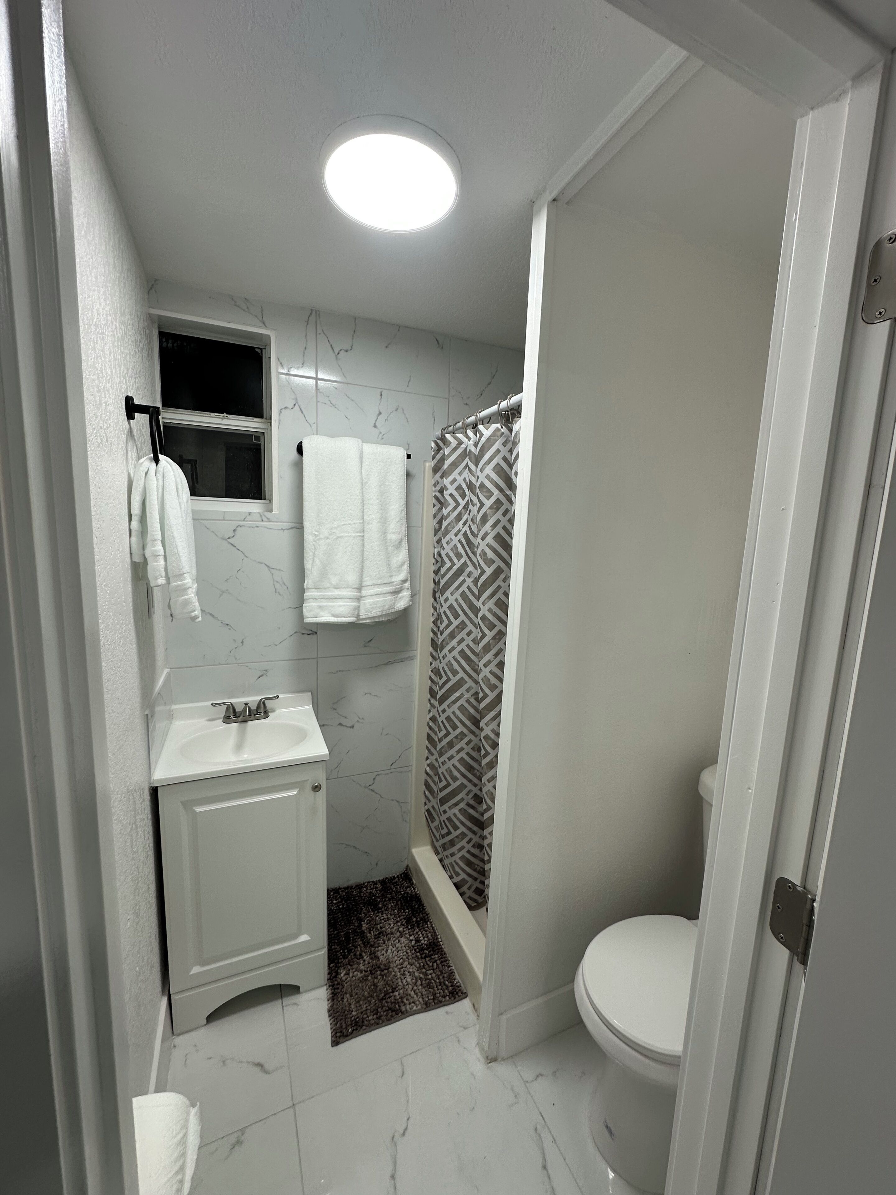 Un baño con inodoro, lavabo y ducha.