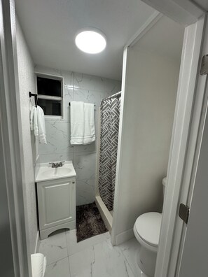 Ein Badezimmer mit Toilette, Waschbecken und Dusche.