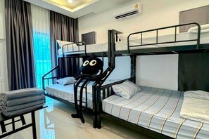 A bunk bed room with a window, curtains, an air conditioner, and a chair. - Sunday Villa Green Mellow Pattaya (Bang Lamung)