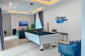 A pool table in a room with a marble wall, a sign reading 'Mellow pool villa,' and a television on the wall. - Sunday Villa Green Mellow Pattaya (Bang Lamung)