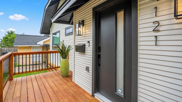 A house with a dark front door, a mailbox, and a green plant on the porch. - EaDo Main House: Sleeps 12, Hot Tub Access, Near Downtown, NRG, Daikin & more (Houston)