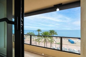 A balcony with a view of the beach, palm trees, and the sea. - LXR Matisse 2-Bedroom, Beachfront (Fuengirola)
