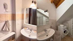 A bathroom with a sink, mirror, towel rack, and a washing machine. - Adelaide in collina, cosy home (Volta Mantovana)