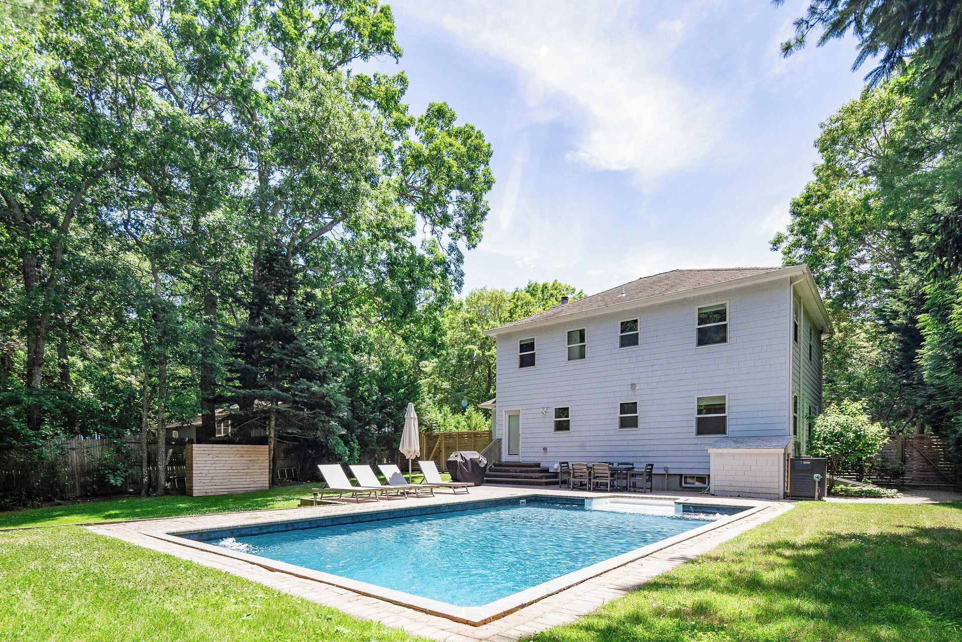A two-story house with a swimming pool in the backyard.