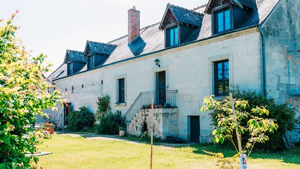 A stone building with a balcony, a staircase, and a small garden area. - Peace, nature and old stones (Berthenay)